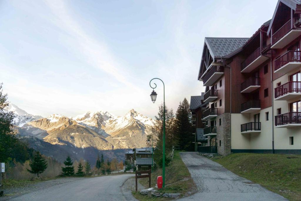 an empty street with mountains in the background at Appart valfrejus in Modane