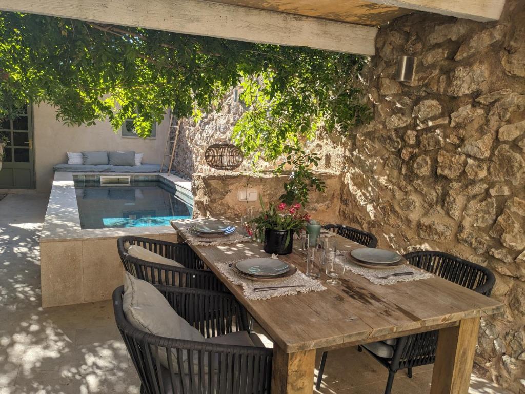 a wooden table and chairs with a table and a pool at Casa Max in Artá