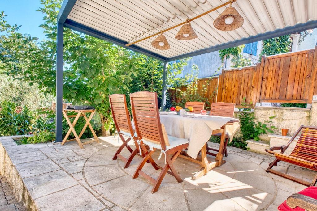 a patio with a table and chairs under a pergola at L'appartement d'Olympe in Périgueux