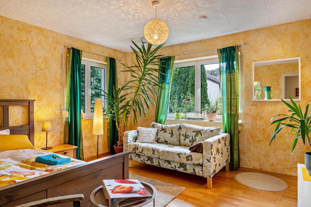 a living room with a bed and a couch at Schönes Zimmer mit eigenem Bad in Albstadt