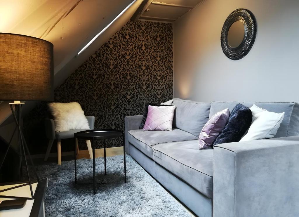 a living room with a couch and a table at Escale Glamour et Chic in Niederbronn-les-Bains