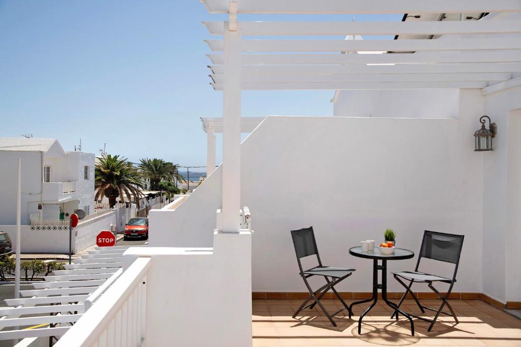 a balcony with a table and chairs on a building at Casa Sabrina, Terraza Vista Mar in Playa Honda
