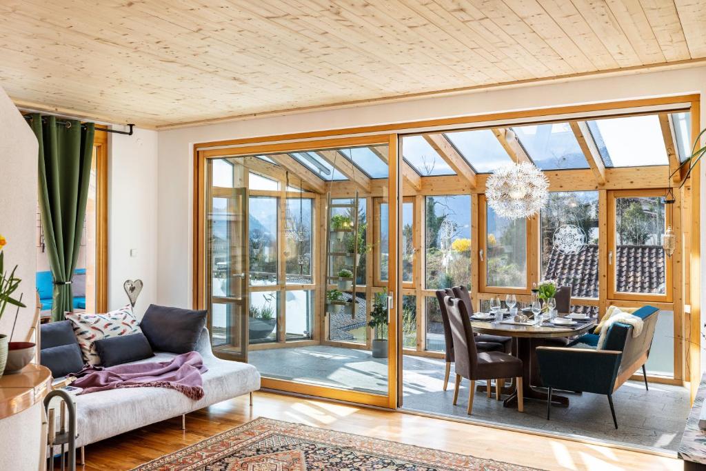 a living room with a table and chairs and glass doors at Ferienwohnung Nearby in Thüringen
