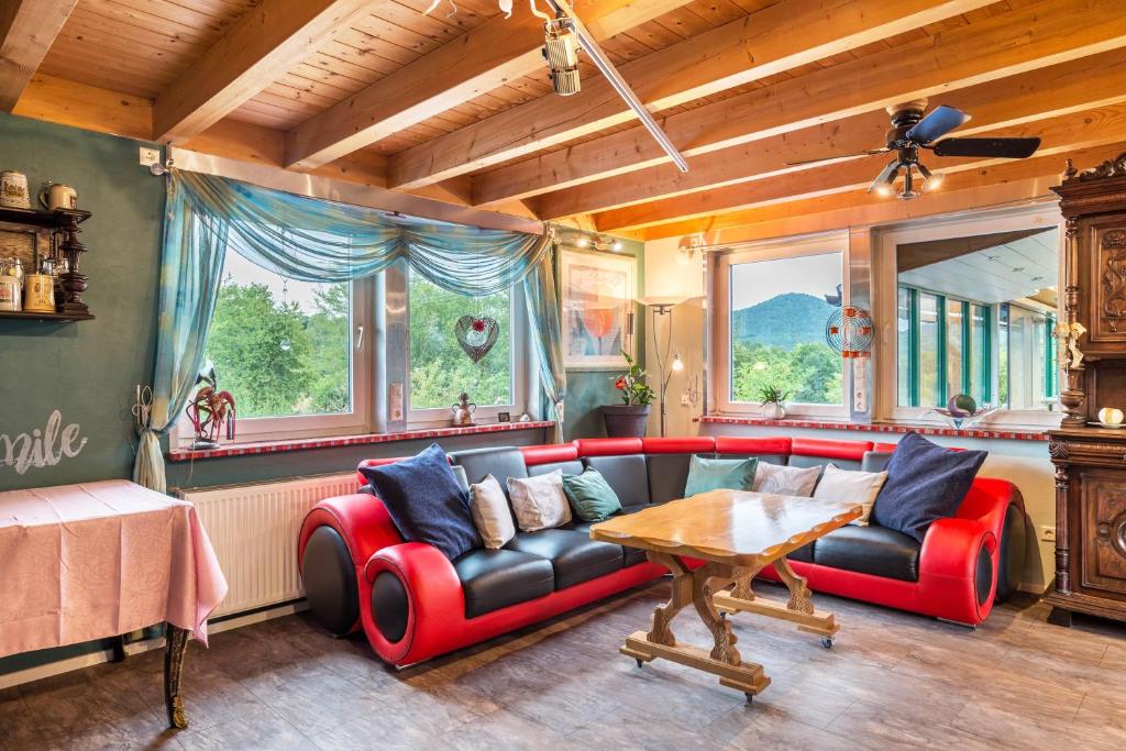 a living room with a red couch and a table at bei den Holzäppeln in Völkersweiler