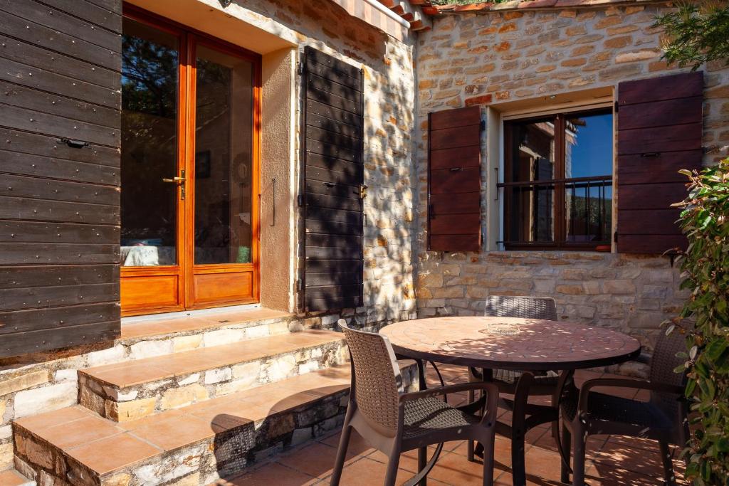 a patio with a table and chairs and a window at Les Cigales in Ceyreste
