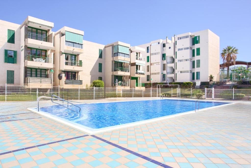 a swimming pool in front of some apartment buildings at Espectacular Y Amplio Las Américas in Playa de las Americas