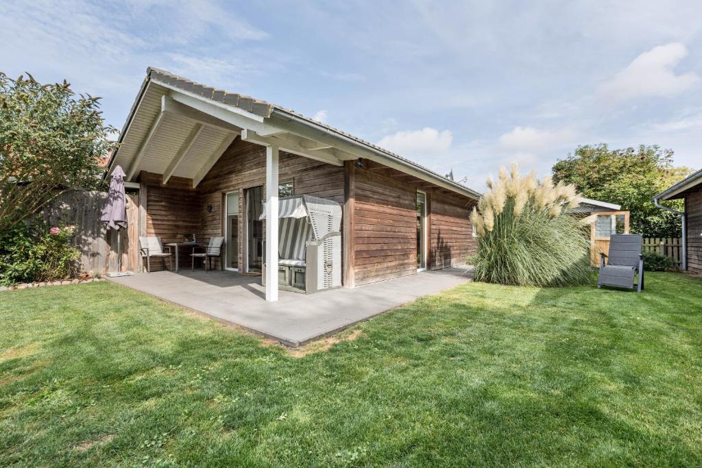 a wooden house with a patio in a yard at Nordlicht in Fehmarn