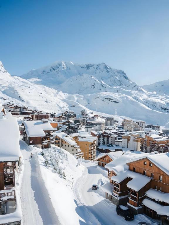 a town covered in snow with mountains in the background at Appartement 6 couchages Val Thorens in Val Thorens