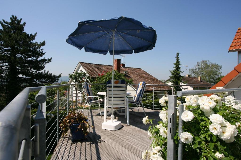 a patio with a table and an umbrella on a deck at Ferienwohnung Ingrid Heyes in Radolfzell am Bodensee