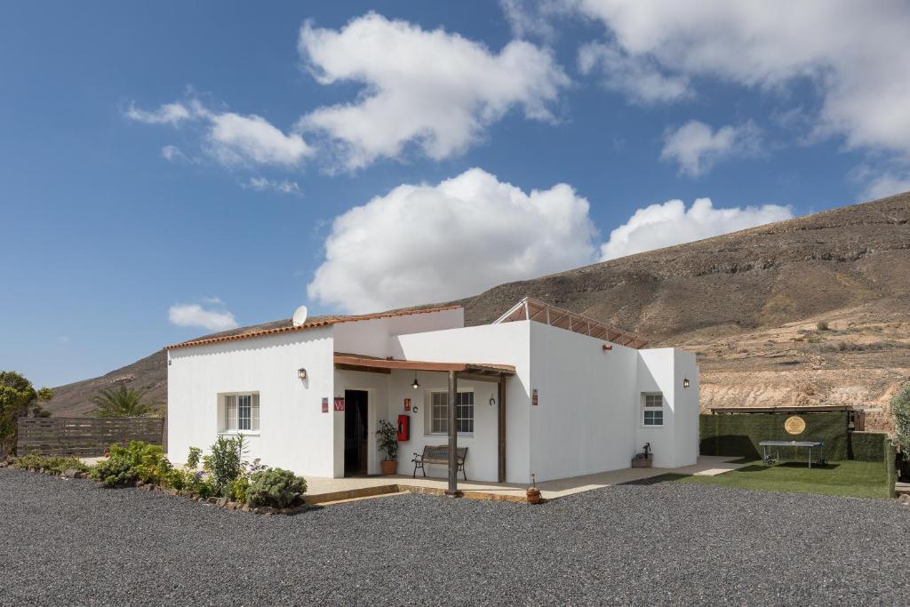 a white house with a hill in the background at Casa Guerepe in La Pared