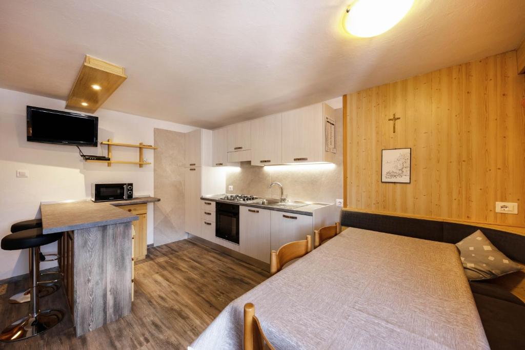 a small kitchen with a table and a dining room at Appartamento Primavera 4 in Moena