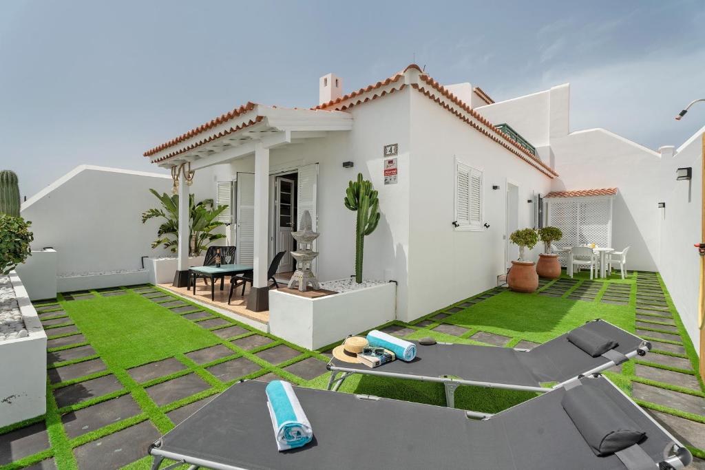 a backyard with a white house with a lawn at Morgana in Abades