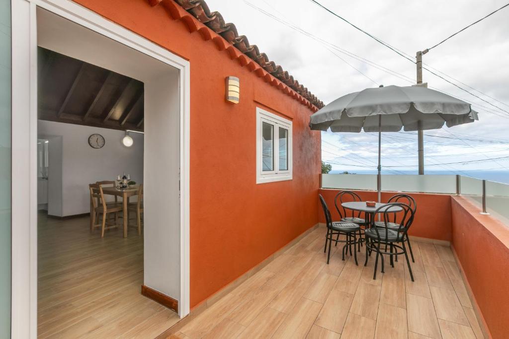 a balcony with a table and chairs and an umbrella at La Gomera in La Victoria de Acentejo