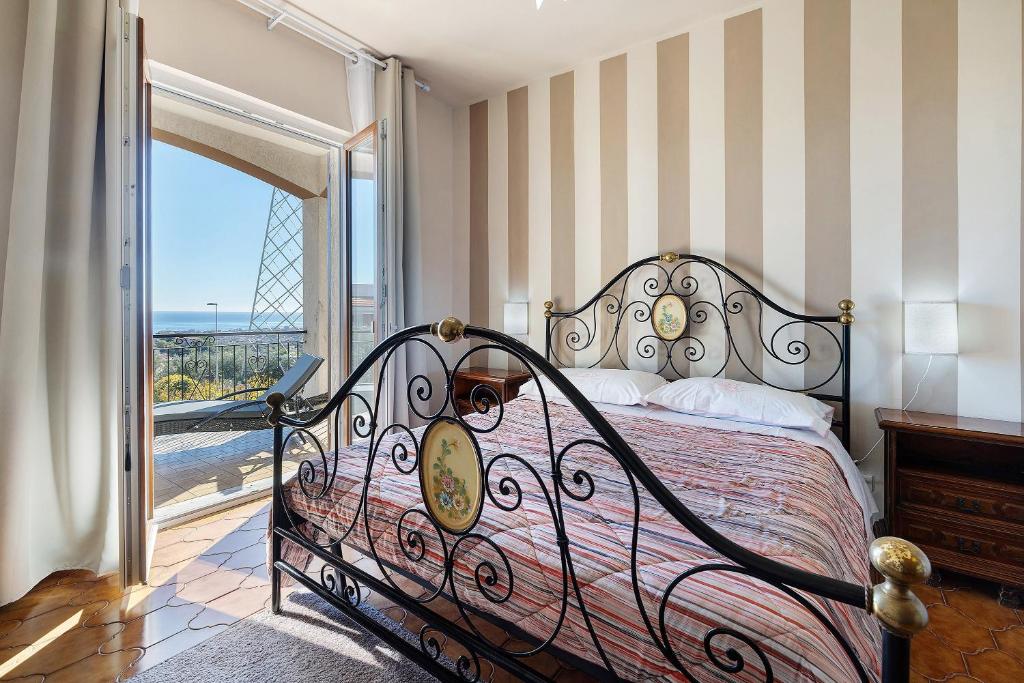 a bedroom with a bed and a balcony with a view at Villa Cristina - vista mare in Boissano