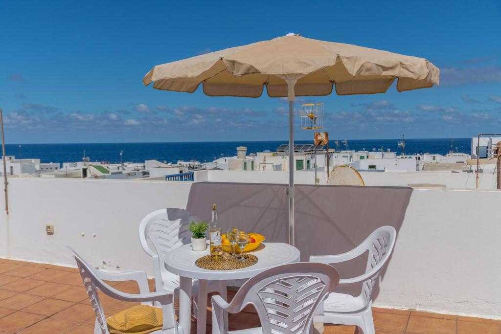 a table and chairs with an umbrella on a balcony at El Barquillo in La Santa