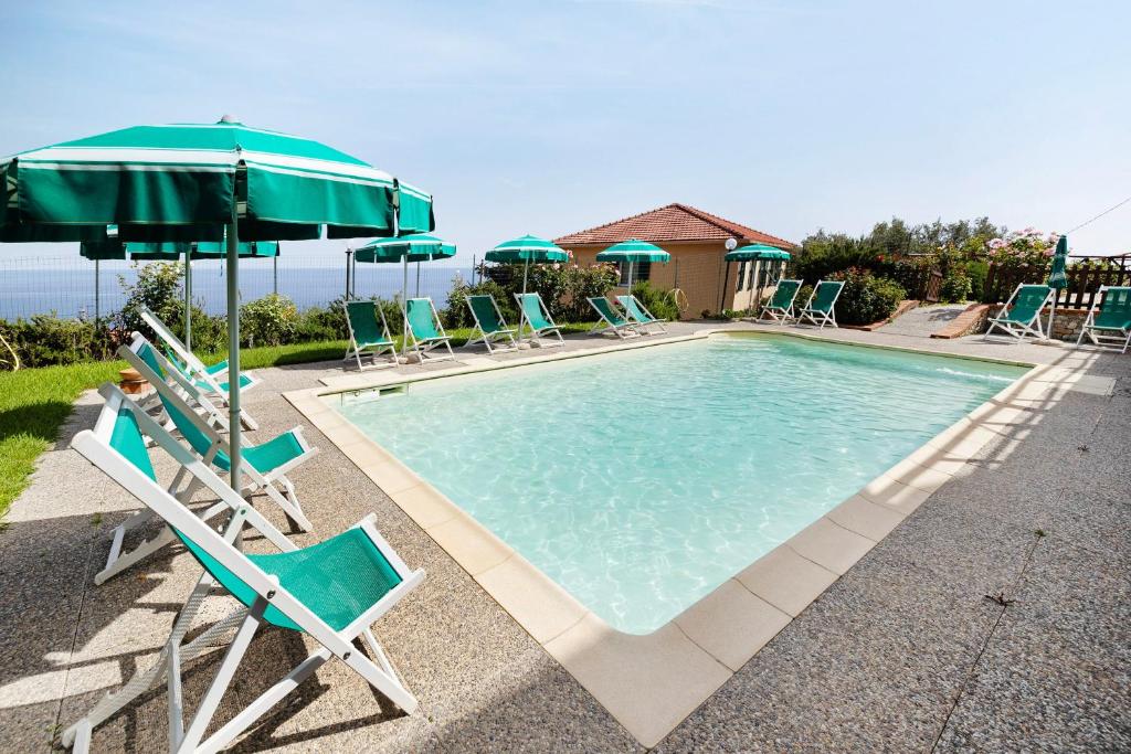 a swimming pool with chairs and umbrellas and a pool at Agriturismo La Realidad in Finale Ligure
