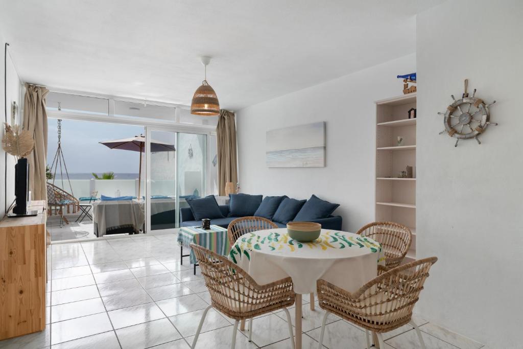 a living room with a table and chairs and a couch at Vistamar in Puerto del Carmen