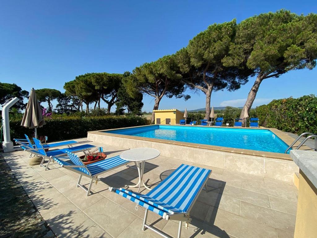 a group of chairs and a table next to a swimming pool at Podere Nuti - 3 Vallino in Cecina