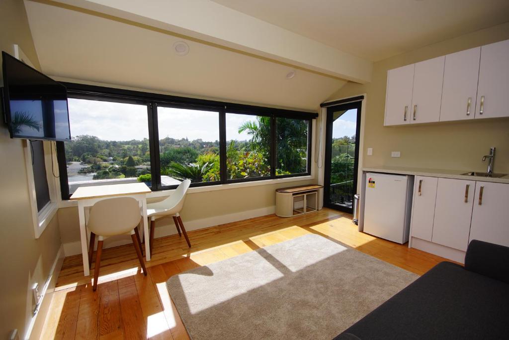 a kitchen with a table and a large window at Riverview Retreat in Kerikeri