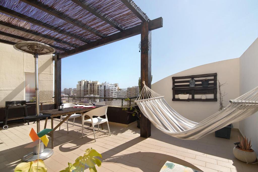 two hammocks on a balcony with a view of the city at Sunset House Algarve in Faro