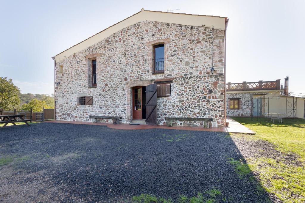 a large stone building with a door on the side at Can Llevorer in Caldes de Montbui