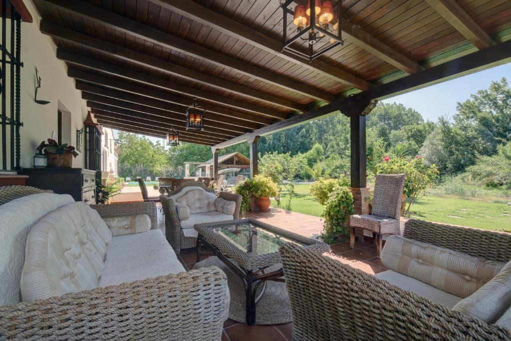 an outdoor patio with wicker chairs and a table at Villa Carmen in Ronda
