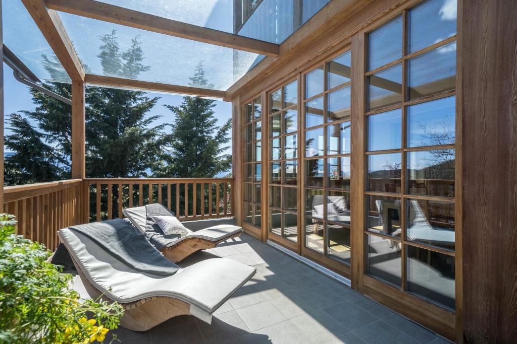 a screened in porch with two chairs and windows at Alber Ferienwohnung Mürri in Verano