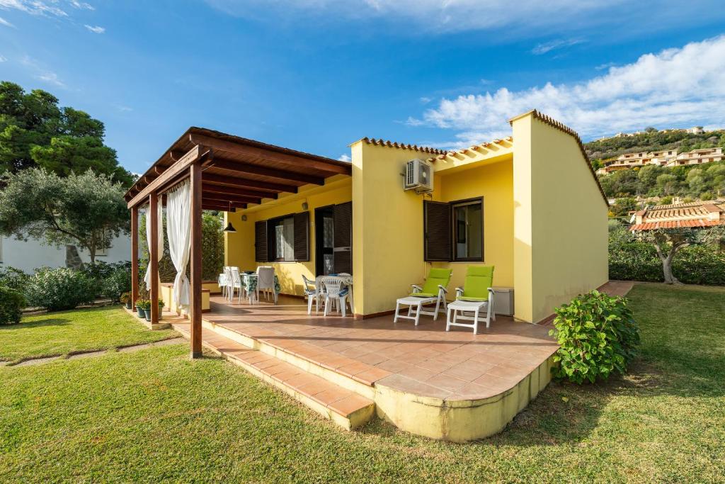 a backyard with a deck and a house at Casa Luisella in Costa Rei