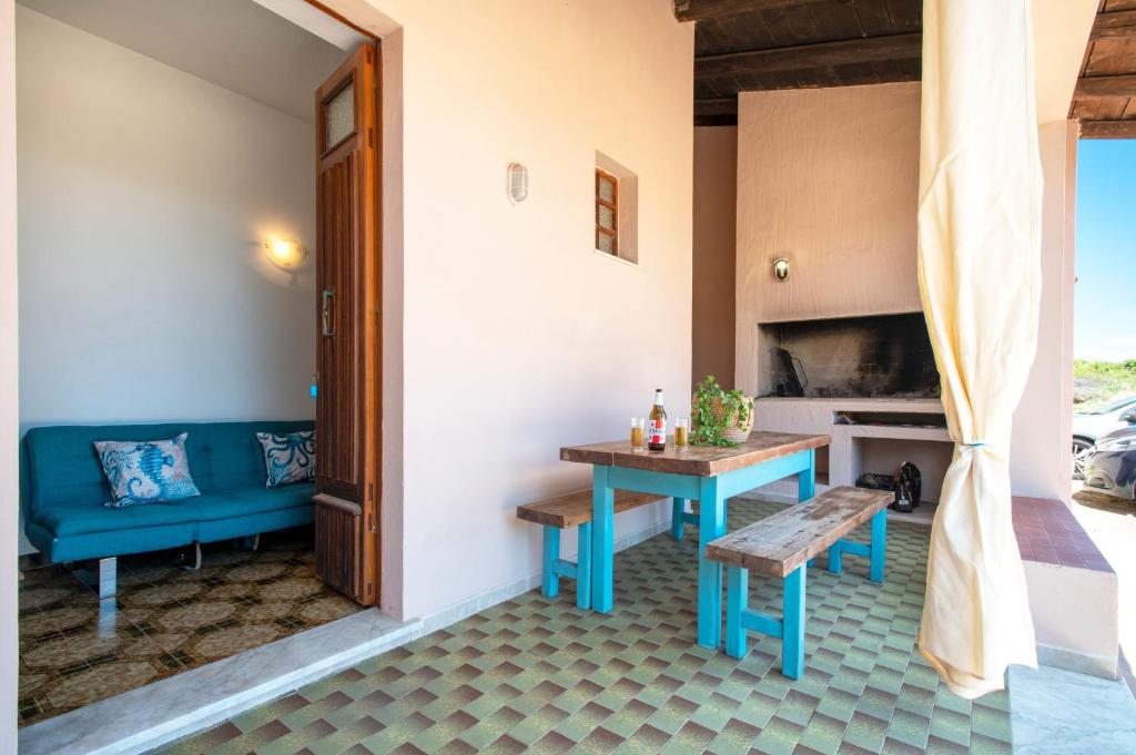 a patio with a table and a bench and a fireplace at Spacious home in Costa Rossa in Trinità d'Agultu e Vignola