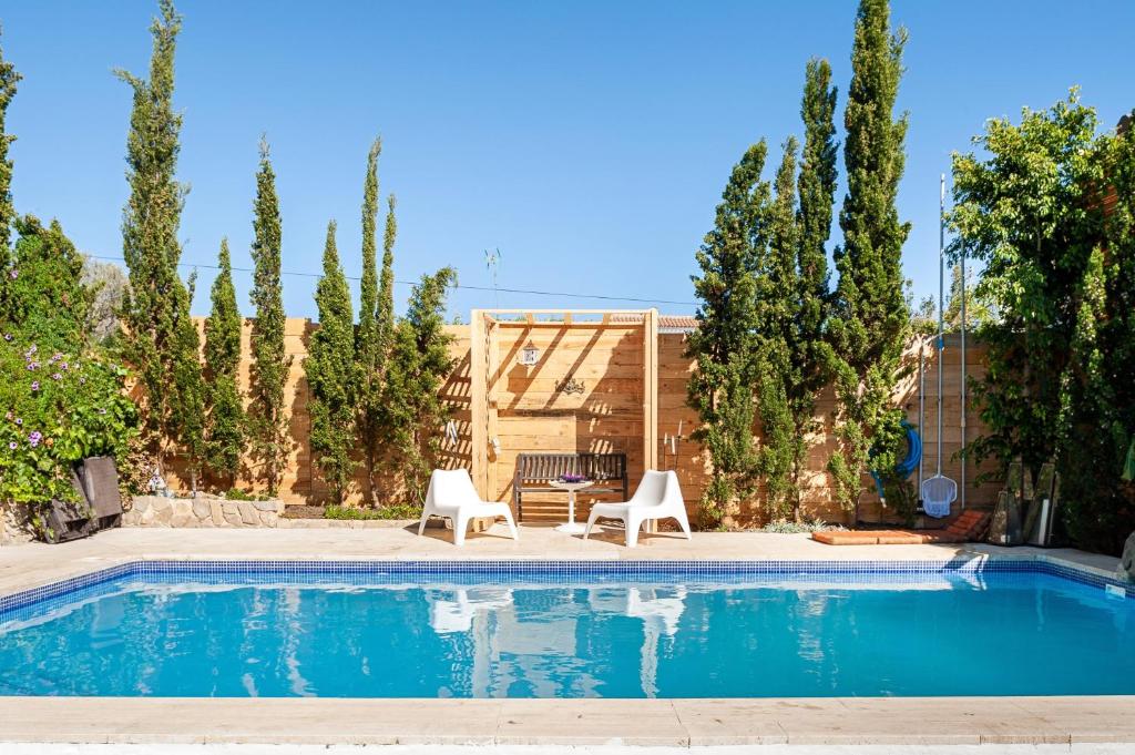 a swimming pool with two chairs and a table at Casa Balcón - Sólo Familias in Los Caños de Meca