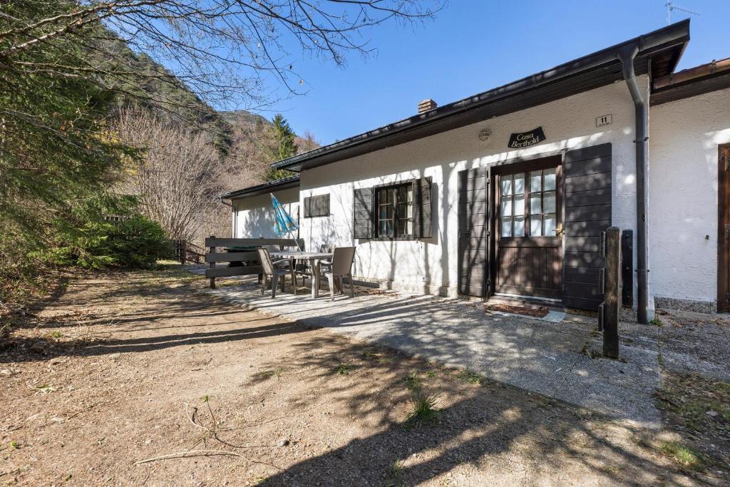 a building with a table and chairs outside of it at Casa Berthold in Ledro