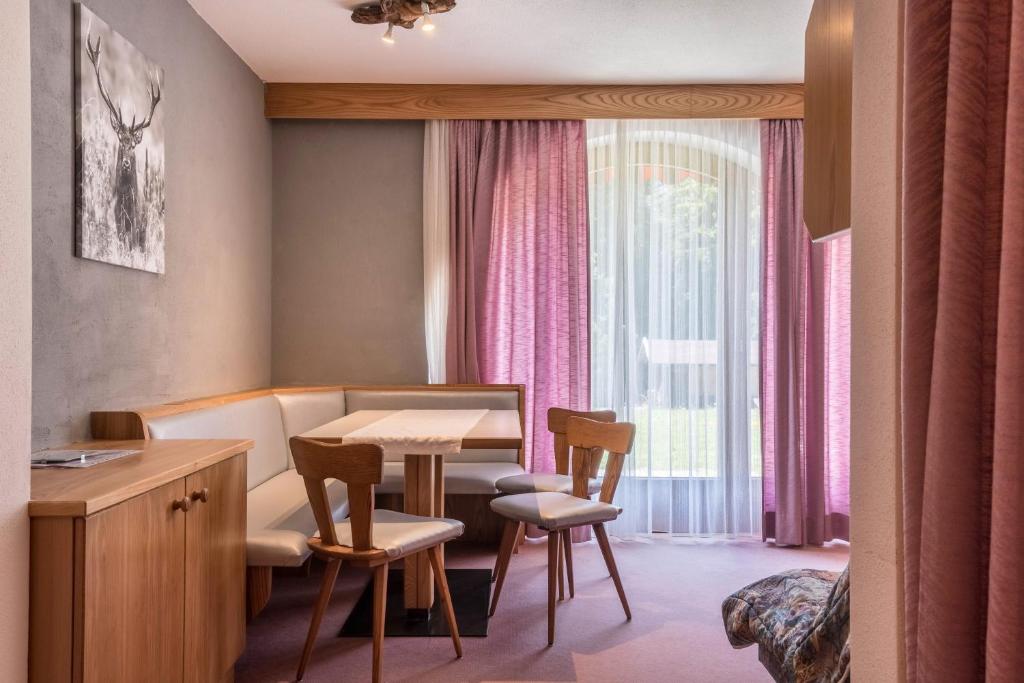 a waiting room with a table and chairs and a window at Sabina Dolomites Euringer in Alpe di Siusi