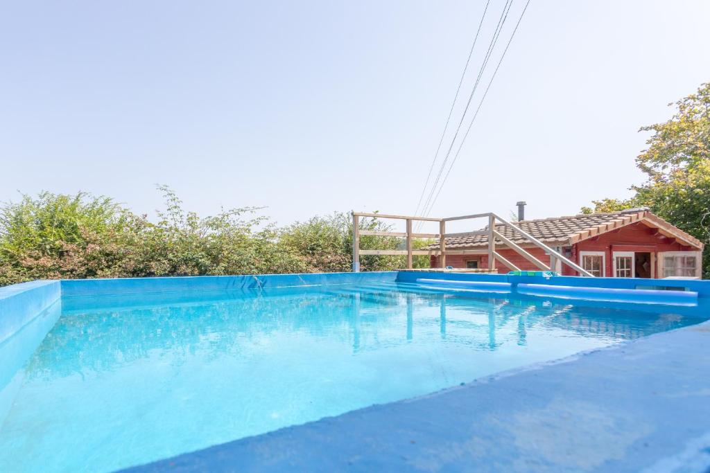 a large blue swimming pool with a house at Peaceful Countryside Getaway in Parbayse