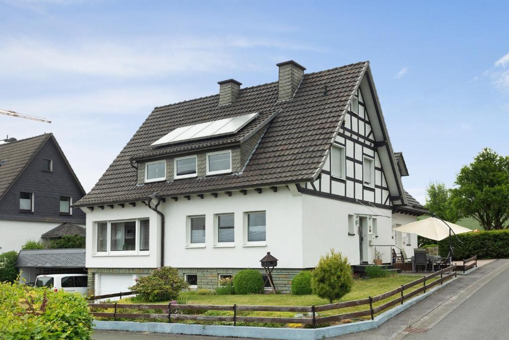 a black and white house with a solar roof at Ferienwohnung Blumenau in Schmallenberg