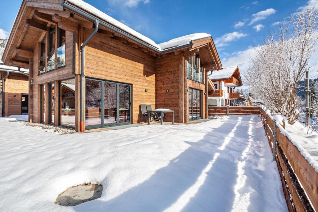 a log home in the snow with a patio at Chalet Aus Holz in Garmisch-Partenkirchen