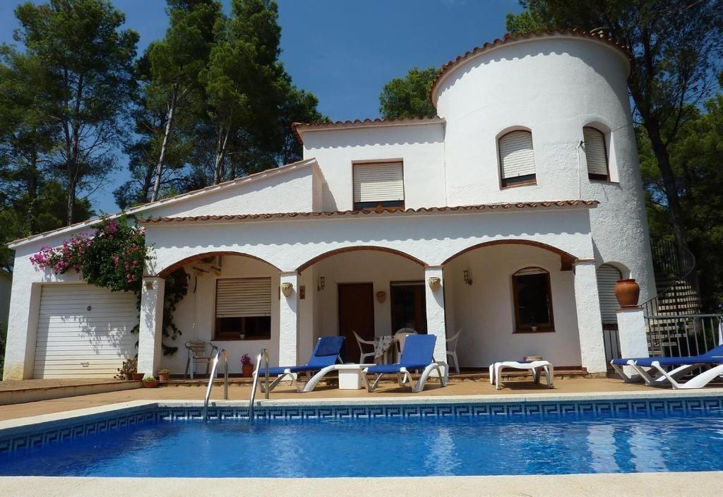 a house with a swimming pool in front of it at El Castillito in Begur