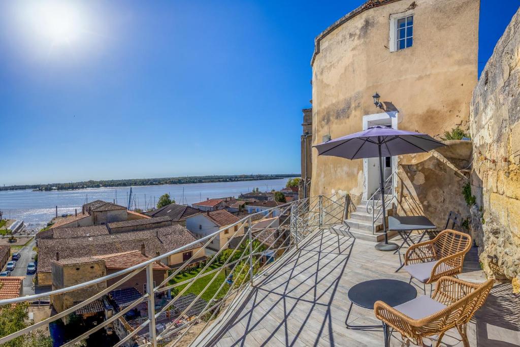 a balcony with a table and an umbrella at Les gîtes de virginie in Bourg-sur-Gironde