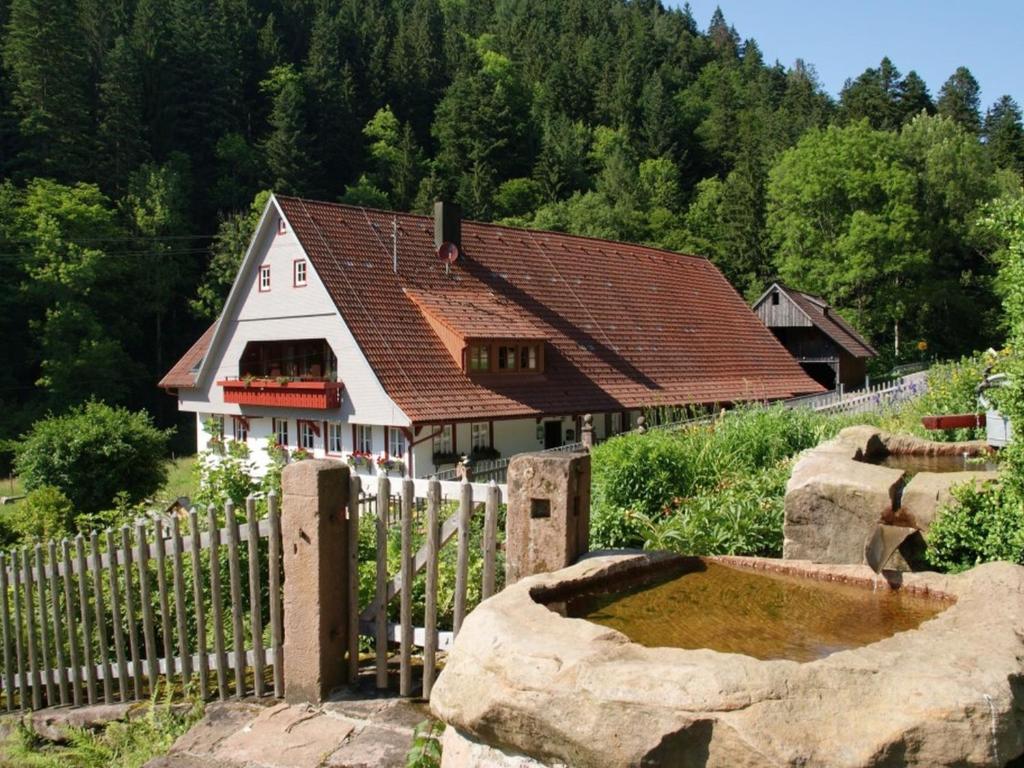 a house with a fence in front of a garden at Appartement Im Hof, 36qm in Schenkenzell