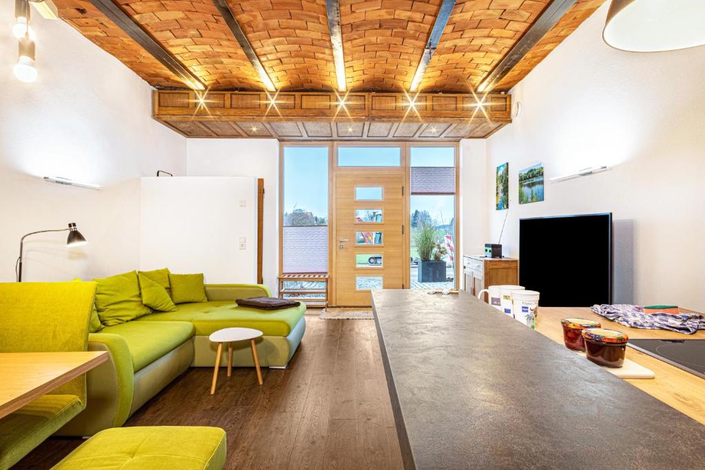 a living room with a green couch and a tv at Käserei in Argenbühl