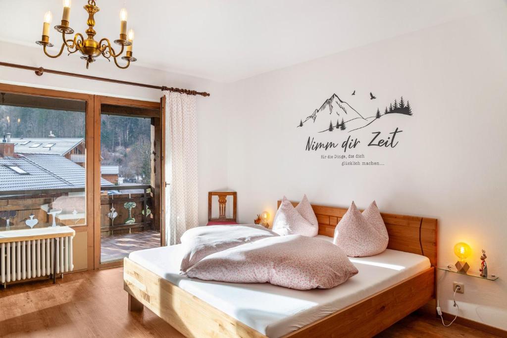 a bedroom with a bed with a sign on the wall at Aschaubichl - Wohnung Bergaurikel in Grainau