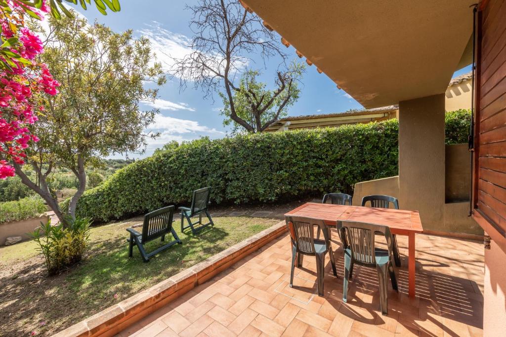 a patio with a wooden table and chairs at Accu is Prezzus E special 50m mare in Villasimius