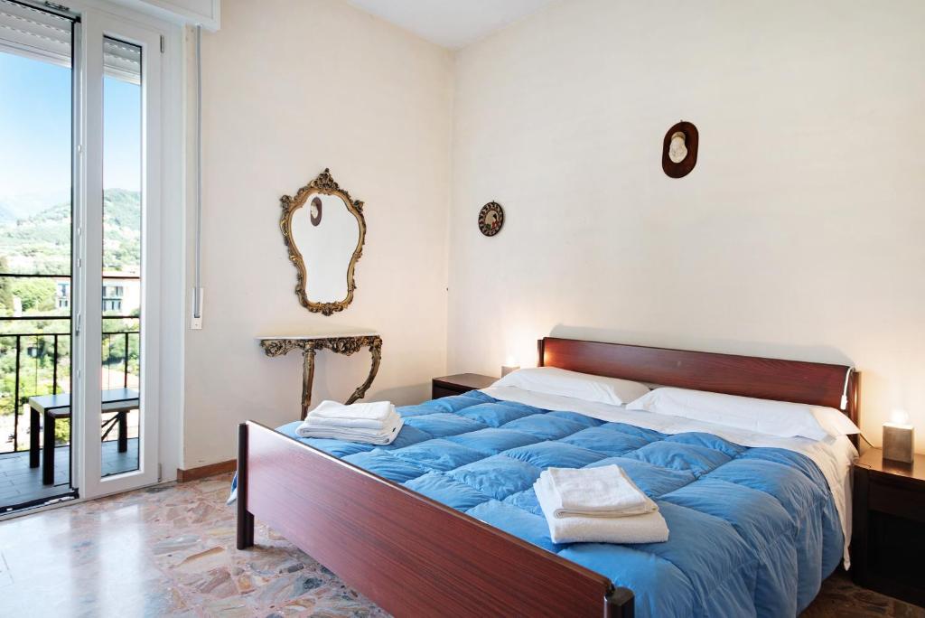 a bedroom with a large blue bed with a mirror at Condominio Sereno in Rapallo