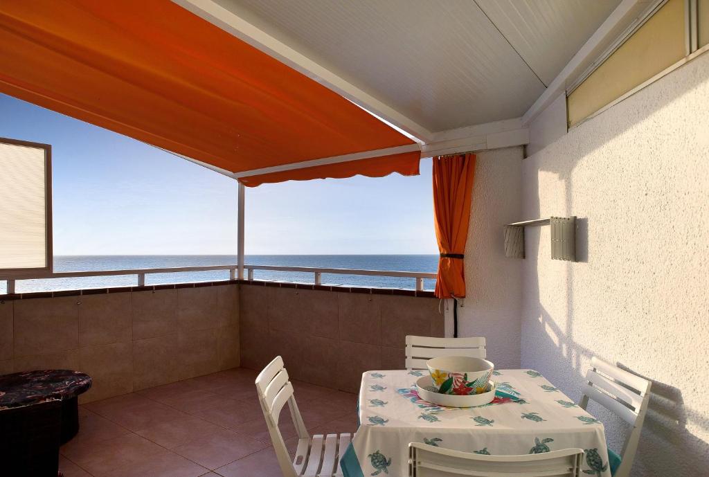 a table and chairs on a balcony with the ocean at Vista Al Paraíso in El Pris