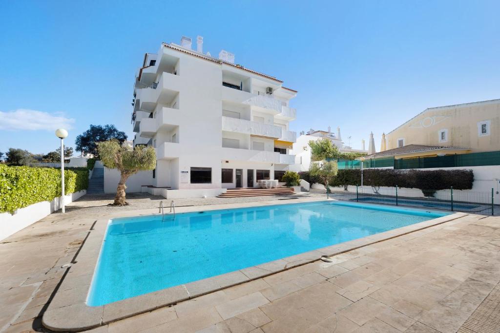 a villa with a swimming pool in front of a building at Dreamalvor in Alvor