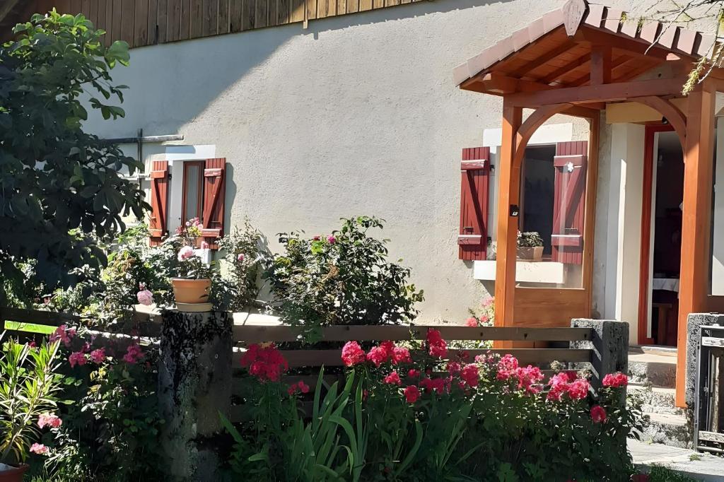a garden with flowers in front of a building at Ancienne petite ferme in Châtelblanc