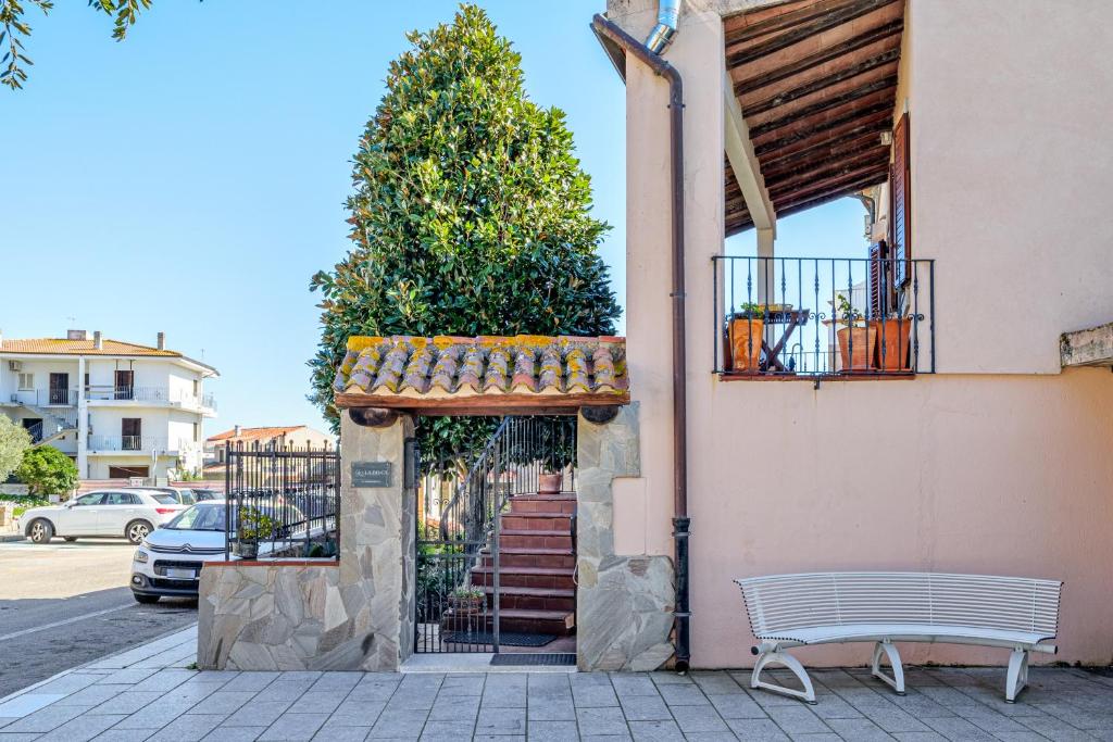 a bench sitting outside of a building with a staircase at Camere La Ro Ca- Telti in Telti
