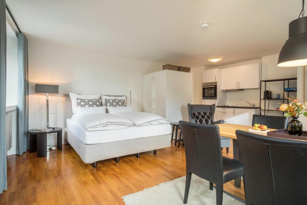 a bedroom with a white bed and a kitchen at 1 Zimmer-appartment Nr 12 in Wangen im Allgäu