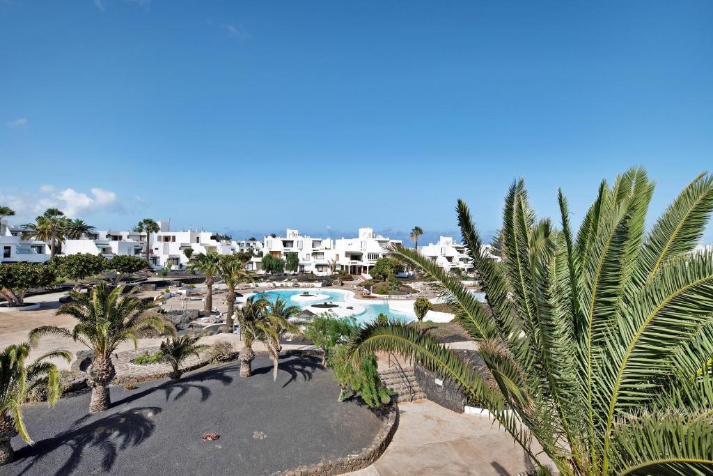an aerial view of a resort with a pool and palm trees at Los Molinos 4306 in Costa Teguise