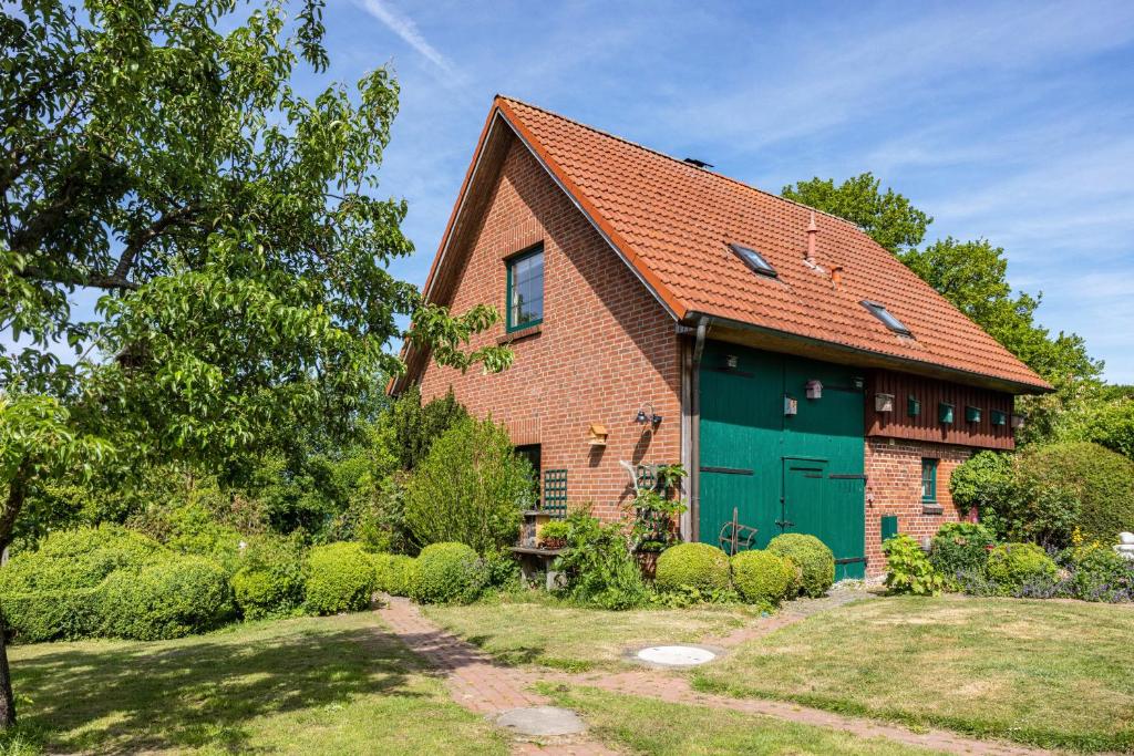 an old brick house with a green garage at Forsthof Schulte in Pronstorf