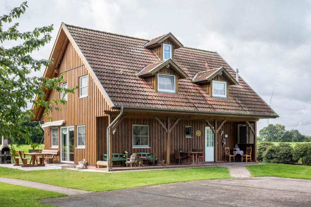 a large wooden house with a gambrel roof at Großes Gästehaus in Sudwalde